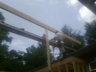 Carpenter setting a ridge beam over a new addition frame — Ice Dam Removal by Roofing Brothers in Osage Beach