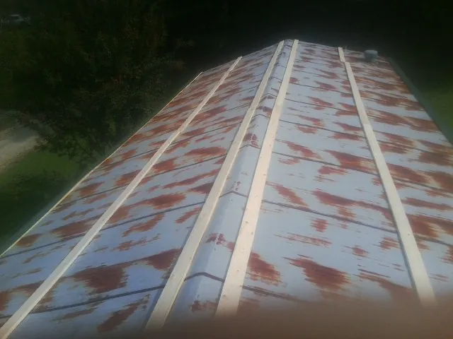 Rusted metal roof panels with new wood purlins before replacement — Storm Damage Roof Repair in Osage Beach by Roofing Brothers