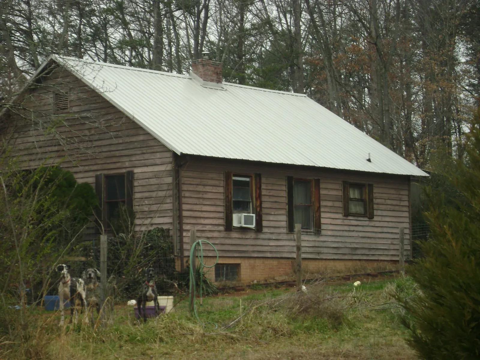 White metal roof on an old wood sided farmhouse, from a Metal Roof Installation job in Osage Beach